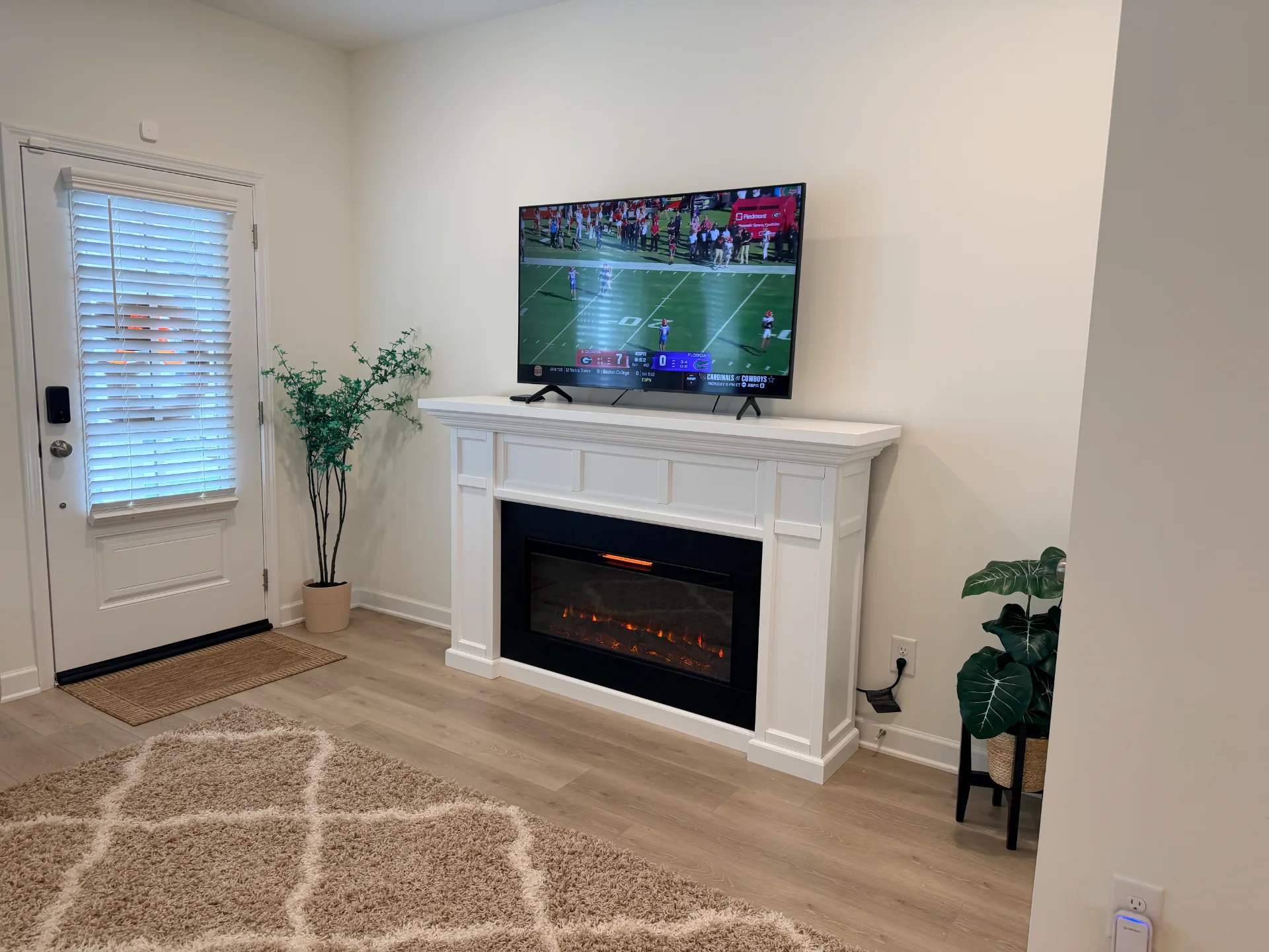 Assembled Real Flame Model 4130 white electric fireplace with mounted TV above, completed by Boxed2Built in a modern living room setting.